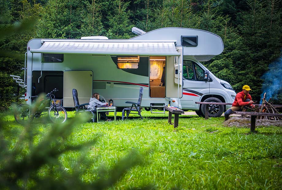 Spacious travel trailer setup with awning and outdoor seating at campground.