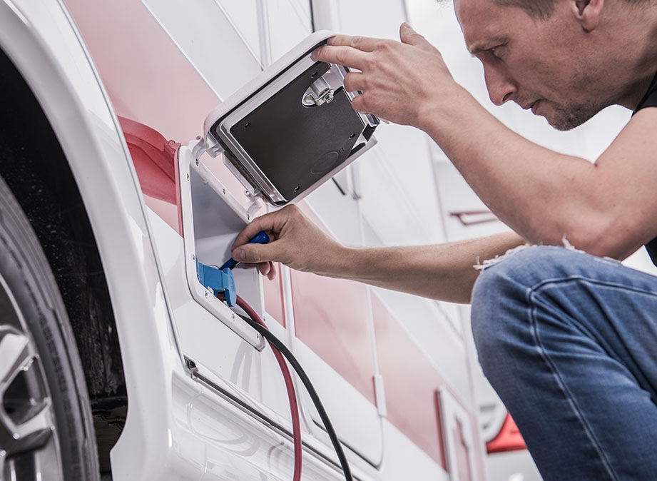 RV technician handling electrical system checks that require professional expertise.