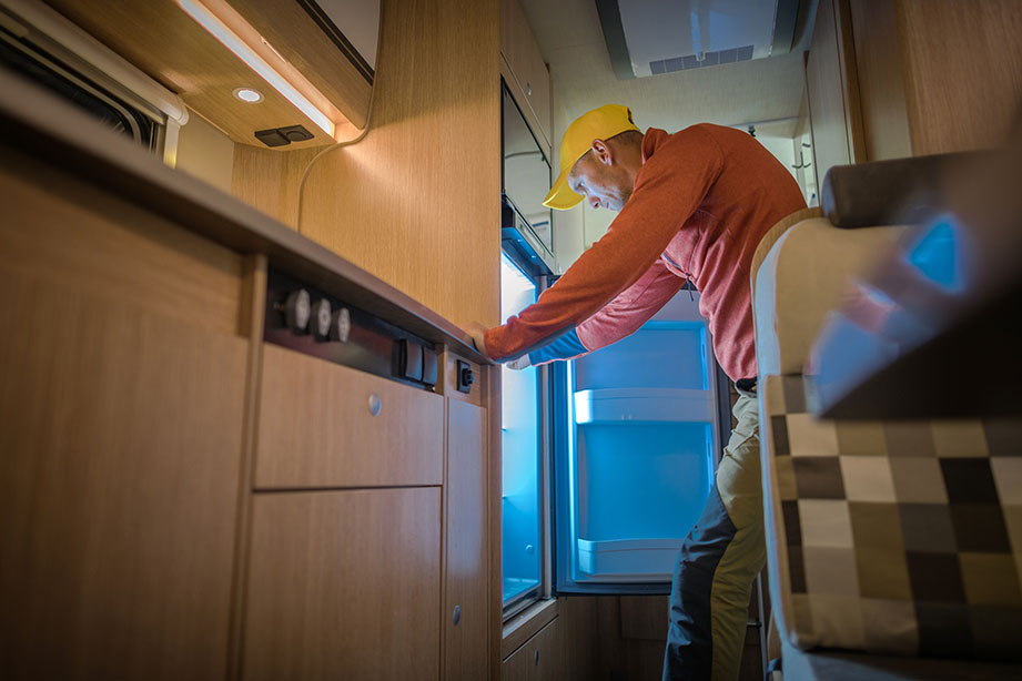 Technician performing seasonal system checks on RV's refrigeration.