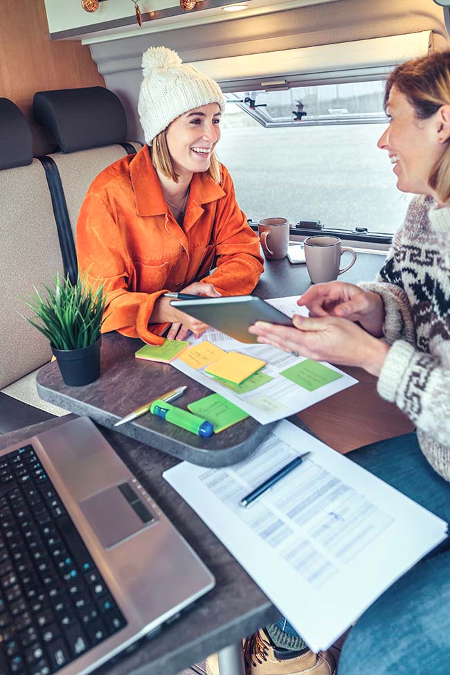 An RV dealer discussing purchase details with a customer inside a model RV.